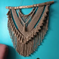 a wall hanging made out of macrame and bamboo sticks with tassels