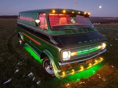 a green van with lights on it parked in the grass