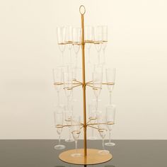 a gold wine glass holder on top of a black table with lots of glasses in it