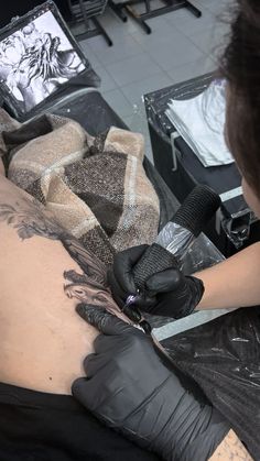 a man getting his tattoo done in a salon