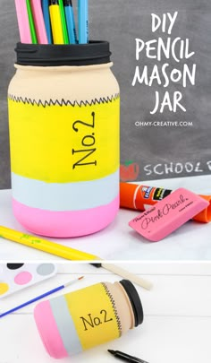 a jar filled with pencils sitting on top of a table next to markers and crayons