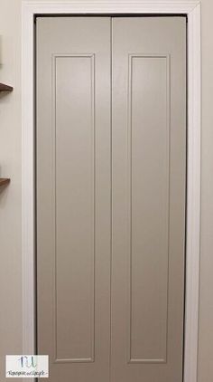 a white door with two brown shelves on the wall and a light fixture above it