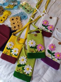 several small purses with flowers on them sitting on a white tablecloth covered surface