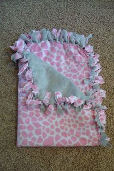 a pink and white giraffe print blanket with ruffles on the bottom