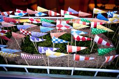 many colorful flags are placed on sticks in a potted plant with moss and rocks