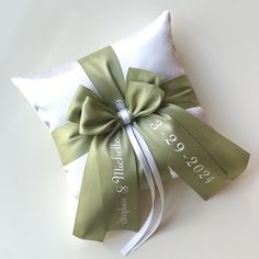 a white pillow with a green ribbon tied around it and the words, wedding date