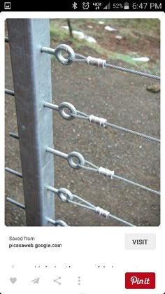 a close up of a metal fence with many links attached to the top and bottom