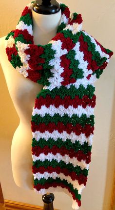 a white mannequin with a red, green and white scarf on top of it