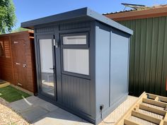 a small shed sitting in the middle of a yard with steps leading up to it