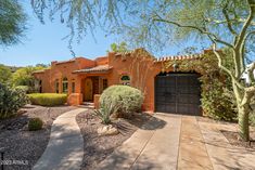 an adobe style home in the desert with cactus and cacti growing around it