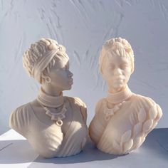 two white statues sitting next to each other