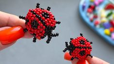 two ladybugs made out of beads are being held by a woman's hand