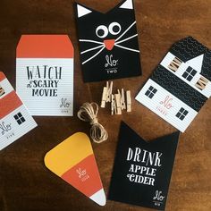 some paper tags are sitting on a table with scissors and other things to make them look like cats