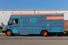 an orange and blue food truck parked in front of a building with the words falafafel on it