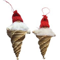 two gnomes are sitting on top of some cones with white fur and red hats