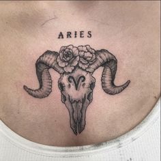 an aries skull with flowers on it's chest and the word aries written in cursive font