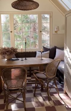 a dining room table and chairs in front of a window