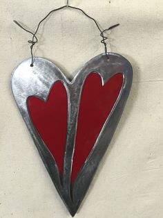 a metal heart with two red hearts hanging from it