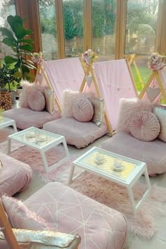 a room filled with lots of pink couches and pillows on top of each other