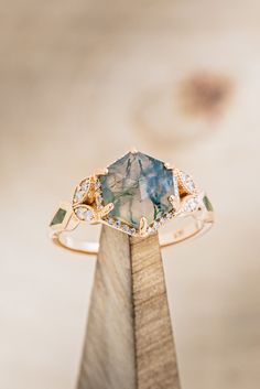 a blue and white ring sitting on top of a wooden stand