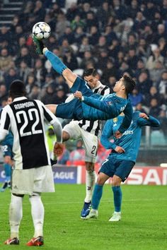 two soccer players colliding for the ball in front of other players during a game