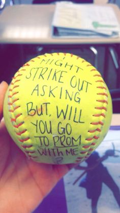 a hand holding a yellow baseball with writing on it that says strike out asking but will you go to prom with me