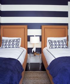 two twin beds in a hotel room with blue and white striped walls