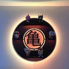 an illuminated clock with some little figurines on it's face in the shape of a circle