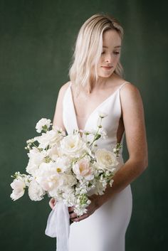 a woman holding a bouquet of white flowers