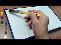 a person is holding a paintbrush over a piece of paper