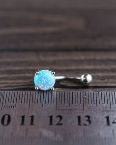 a pair of opalite earrings sitting on top of a measuring ruler with the end cut out