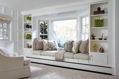 a living room filled with lots of white furniture