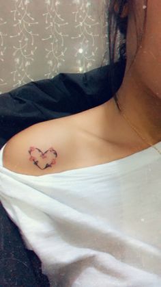 a woman with a heart tattoo on her chest