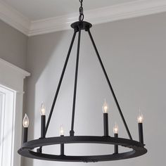 a chandelier hanging from the ceiling in a room with gray walls and white trim