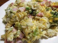 a white plate topped with macaroni and cheese covered in broccoli florets