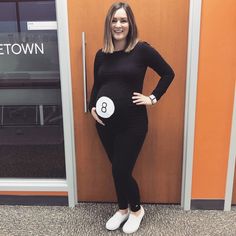 a pregnant woman standing in front of a door