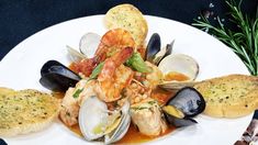 a white plate topped with seafood and mussels