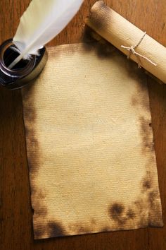 an old paper, pen and inkwell on a wooden table with a feather quill