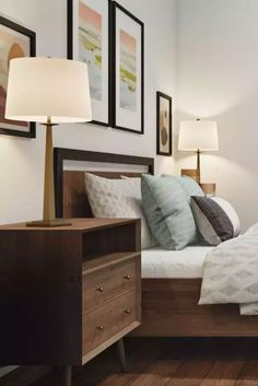 a bed sitting in a bedroom next to two lamps on either side of the bed