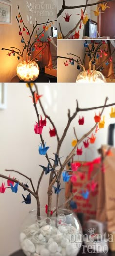 a vase filled with rocks and paper birds on top of a table next to a tree