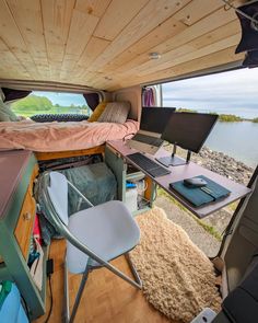 the interior of a camper with a bed, desk and computer on top of it