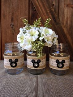 three mason jars with flowers in them on a table