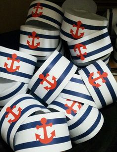 there are many blue and white striped cups with red anchors on them in the shape of an anchor