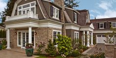 a large house with lots of windows and landscaping