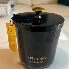 an empty black container sitting on top of a white table with a yellow tag hanging from it