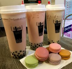 three iced drinks and four macaroons on a table