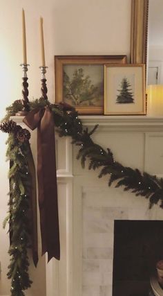 a mantel decorated for christmas with candles and garland