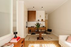 a living room filled with furniture next to a kitchen and dining room table on top of a hard wood floor