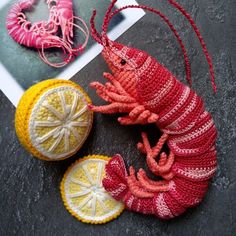 two crocheted seahorses are next to an orange and a lemon slice