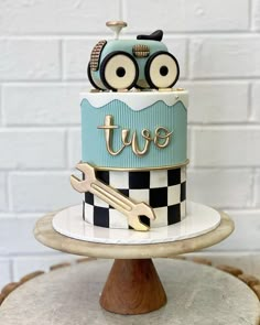 a blue and white cake sitting on top of a wooden stand next to a brick wall